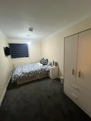 a bedroom with a bed and a window at Barnfield Rooms in Chelmsford