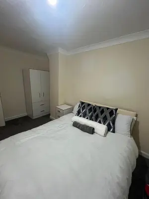 a bedroom with a large white bed with two pillows at Barnfield Rooms in Chelmsford