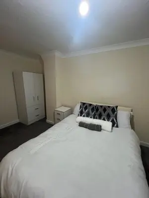 a bedroom with a large white bed with two pillows at Barnfield Rooms in Chelmsford