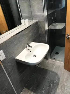 a bathroom with a white sink and a shower at Gidea Park Hotel in Romford