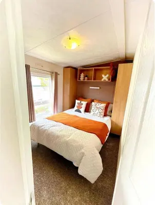 a bedroom with a bed and a window in it at Harwich - Caravan - Sleeps 10 - Garden - Pool in Harwich