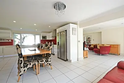 a kitchen and living room with a table and chairs at Modern home in historic market town near airport in Saffron Walden