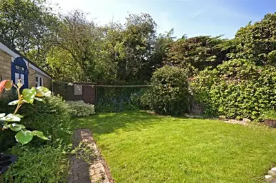 a backyard with a yard with a fence and green grass at Modern home in historic market town near airport in Saffron Walden