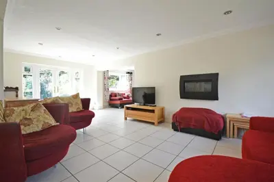 a living room with red furniture and a tv at Modern home in historic market town near airport in Saffron Walden