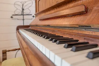 a close up of a wooden piano keyboard at Sea Holly Cottage, Aldeburgh in Aldeburgh