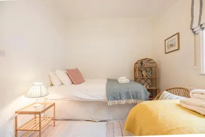 a small bedroom with a bed and a table at Sea Holly Cottage, Aldeburgh in Aldeburgh
