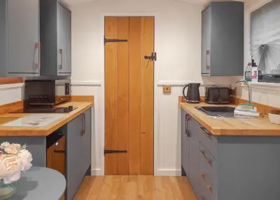 a kitchen with wooden counters and a wooden door at Fenview Lakes in Ely