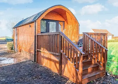 a wooden building with a wooden gate and a wooden ramp at Fenview Lakes in Ely