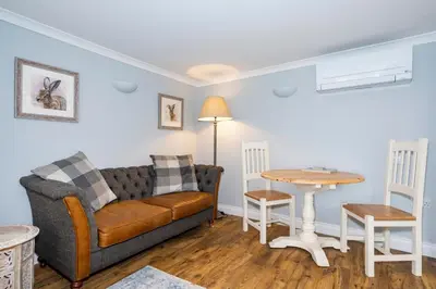 a living room with a couch and a table at Holly House Studio, Lavenham in Lavenham