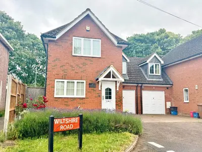 a brick house with a sign in front of it at Park Villa, Stevenage in Shephall