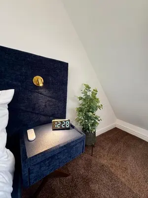 a room with a bed with a table and a plant at Park Villa, Stevenage in Shephall