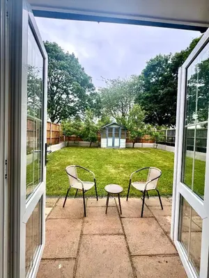 two chairs and a table sitting on a patio at Park Villa, Stevenage in Shephall