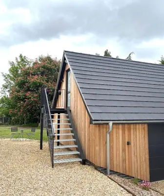 a building with a staircase and a roof at The Cartlodge - Studio Loft Apartment in Horringer, Bury St Edmunds in Westley