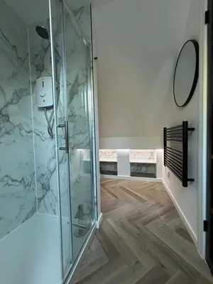 a shower stall in a bathroom with marble walls at The Cartlodge - Studio Loft Apartment in Horringer, Bury St Edmunds in Westley