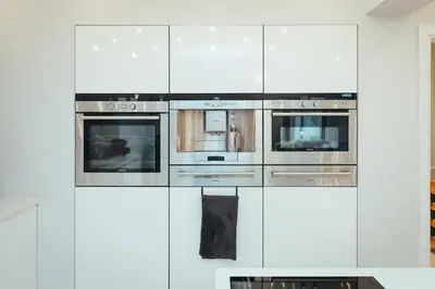 a kitchen with white cabinets and two ovens at 5 Bed Family Home- Free Parking in Woodham Ferrers Station