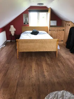 a bedroom with a bed with a wooden floor at Country View place in Weeley