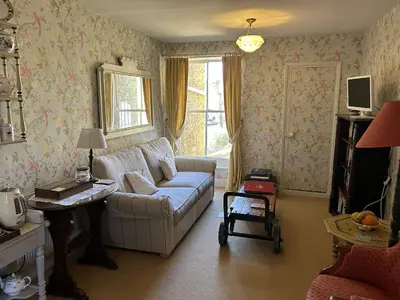 a living room with a couch and a table at Peacocks Tearoom and Fine B&B in Ely