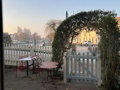 a white fence with a table and chairs in front of it at Peacocks Tearoom and Fine B&B in Ely