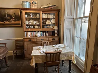 a dining room with a table and a hutch at Peacocks Tearoom and Fine B&B in Ely