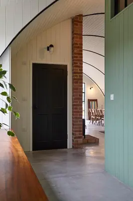 a hallway with a black door in a building at Converted Nissen Barn on beautiful farm in Braintree