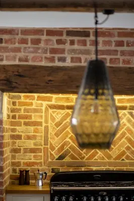 aendant light hanging from a brick wall at Farmhouse in Suffolk with wild swimming & hot tub in Saint Margaret