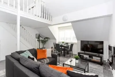 a living room with a couch and a table at 1 Bed Split Level Apartment- Leigh-on-Sea in Southend-on-Sea
