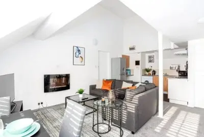 a living room with a couch and a table at 1 Bed Split Level Apartment- Leigh-on-Sea in Southend-on-Sea