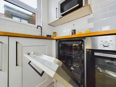 a kitchen with an open dishwasher and a microwave at Westcliff apartment with free parking in Southend-on-Sea