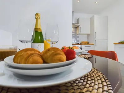 a plate of bread and strawberries on a table with wine glasses at Westcliff apartment with free parking in Southend-on-Sea