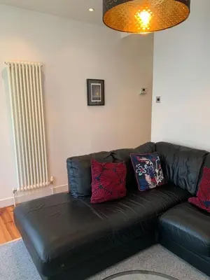 a black leather couch with pillows in a living room at 3 Bed Family House Free Parking in Southend-on-Sea
