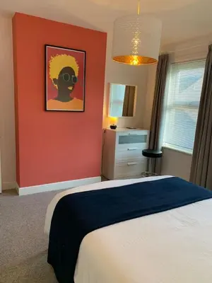 a bedroom with a bed and a red wall at 3 Bed Family House Free Parking in Southend-on-Sea