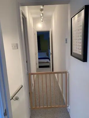 a hallway with a staircase leading to a room with a bed at 3 Bed Family House Free Parking in Southend-on-Sea