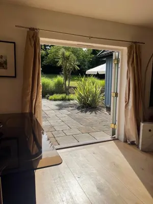 an open door to a patio in a house at Charming Cottage nestled in the heart of a picturesque village in Westleton