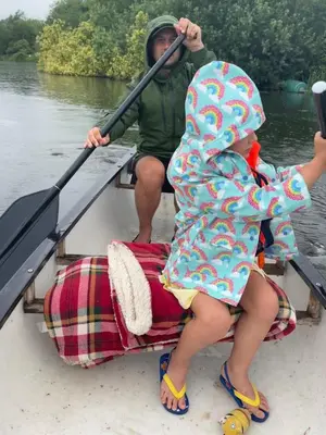 a man and two children sitting in a row boat at Outbuilding with river views in Cambridgeshire in Holywell