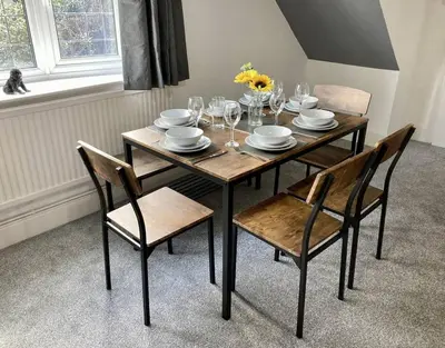 a dining room table with chairs and plates and glasses at Brackens House Brentwood in Little Warley