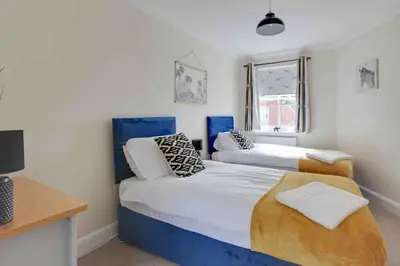 a bedroom with two beds and a desk at Elizabeth Four Bedroom Townhouse in Bocking Churchstreet