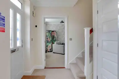 a hallway with a stairway leading to a living room at Elizabeth Four Bedroom Townhouse in Bocking Churchstreet