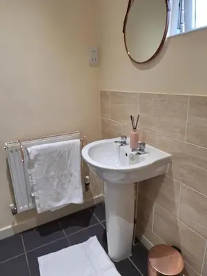 a bathroom with a white sink and a mirror at Happy place in Milton