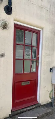 a red door on the side of a building at Priory View in Saint Osyth
