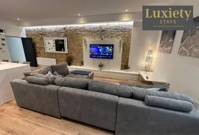 a living room with a large couch and a tv at Sleek & Stunning 2BR APT By Luxiety Stays Short Lets & Serviced Accommodation Southend on sea With Free WiFi, Smart TV, Netflix in Southend-on-Sea