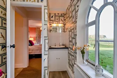 a bathroom with a window and a room with a bed at 1 Bed in Wymondham oc-w30597 in Wymondham