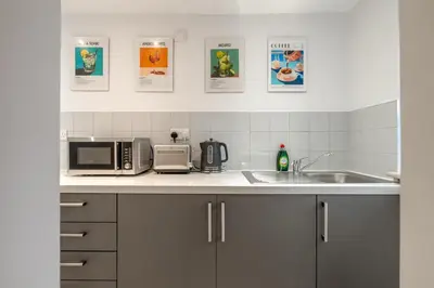 a kitchen counter with a microwave and a sink at Newmarket House 5 Bedroom 5 En-suite Free Parking in Newmarket