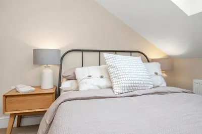 a bedroom with a bed and a night stand with a lamp at 7D Albert St - sleeps 4 guests with parking on request in Bury Saint Edmunds
