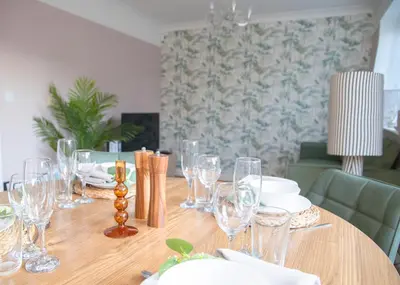 a wooden table with glasses and plates on it at 3x Bed Elegant House with Private Parking in Sawston