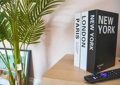 a book sitting on a table next to a remote control at 3x Bed Elegant House with Private Parking in Sawston