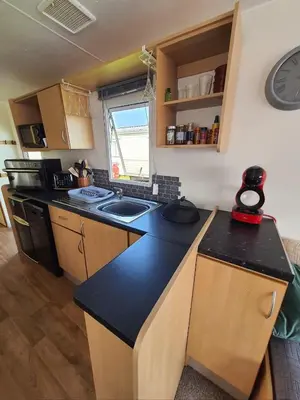 a kitchen with a black counter top in a room at Buxton's Holiday Home - Park Holiday's complex - Beach Access - Free WiFi in Saint Osyth
