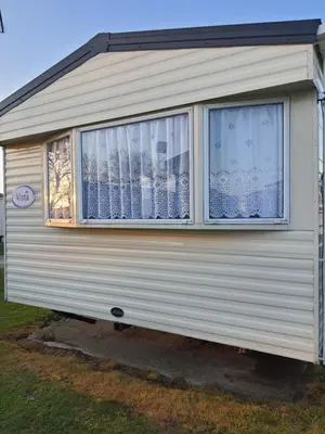a white caravan with a window on the side of it at Buxton's Holiday Home - Park Holiday's complex - Beach Access - Free WiFi in Saint Osyth