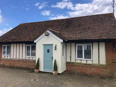 a small brick house with a blue door at Acorn Cottage at Finchingfield Holiday Cottages in Finchingfield