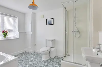 a white bathroom with a toilet and a shower at Acorn Cottage at Finchingfield Holiday Cottages in Finchingfield