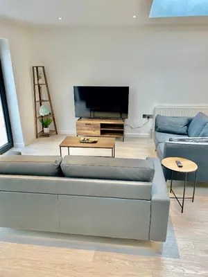 a living room with a couch and a tv at beautiful 3 bedroom apartment in cambridge sleeps 7 in Milton